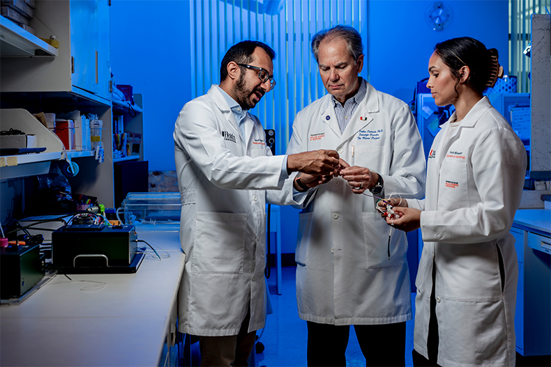 Dr. Suhrud Rajguru (professor of biomedical engineering & otolaryngology), Dr. Dalton Dietrich (professor of neurological surgery), and Kayla Minesinger (Ph.D. student in biomedical engineering) at the Miami Project to Cure Paralysis.