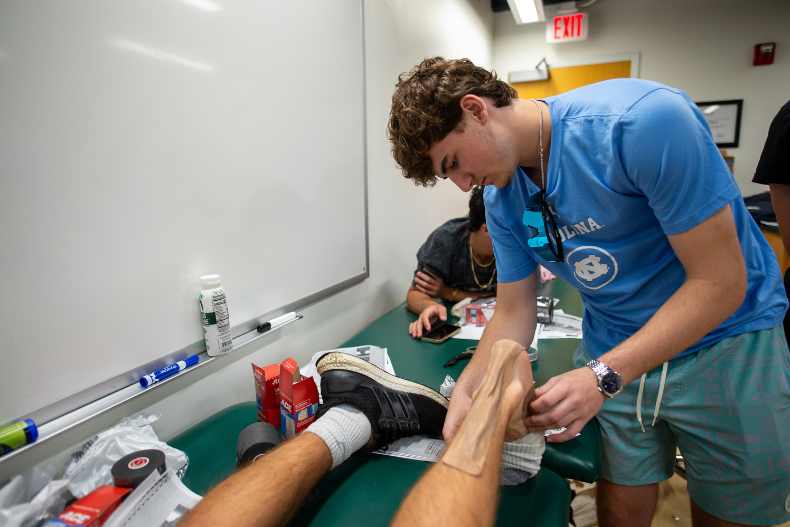 Taylor Billups, 16, tends to a simulated injury on another student during a sports medicine class he took as part of the 2023 Summer Scholars Pre-College Program. Photo by Armando Rodriguez