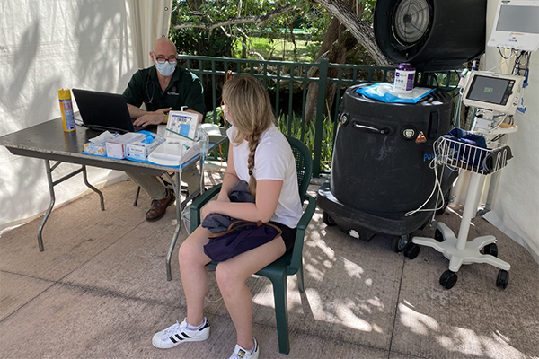 Joseph Reinhardt, a physician for Student Health Service, meets with a student in the prescreening area outside of the Lennar Foundation Medical Center in early March.