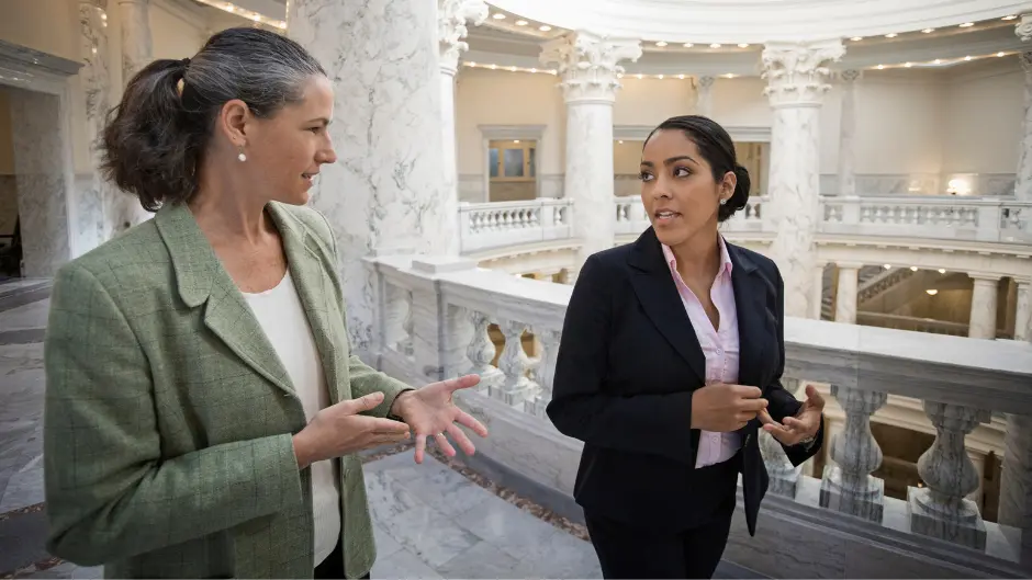Women with map jobs walk the the halls of a government building
