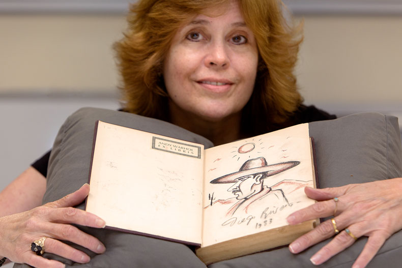 Catherine Steele poses with a book containing a sketch done by Diego Rivera. Photo: Joshua Prezant/University of Miami