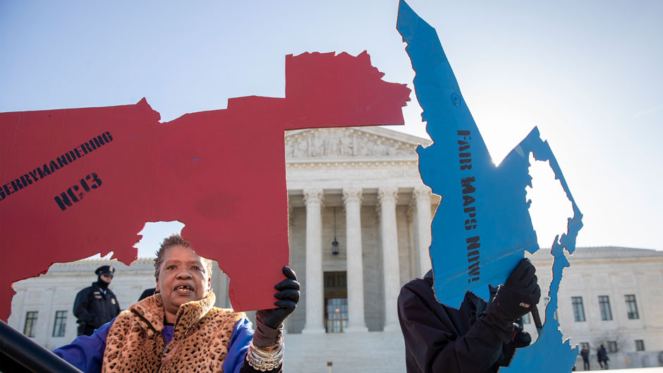 Activists at the Supreme Court opposed to partisan gerrymandering hold up representations of congressional districts from North Carolina, left, and Maryland, right. Photo: Carolyn Kaster/Associated Press