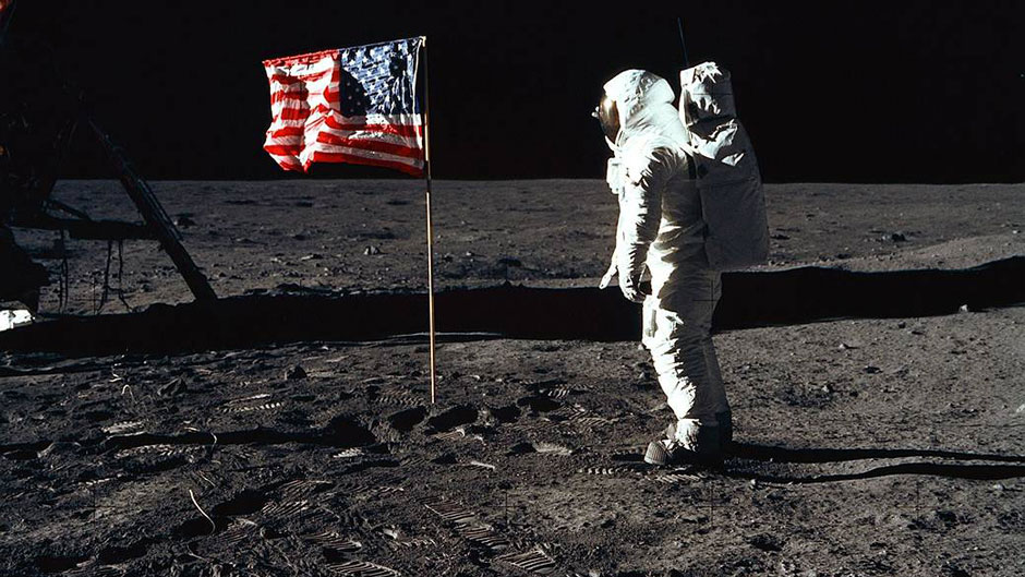 Astronaut Edwin E. Aldrin Jr., lunar module pilot of the first lunar landing mission, poses for a photograph beside the deployed United States flag during an Apollo 11 extravehicular activity (EVA) on the lunar surface.