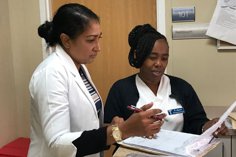 Dr. Indira Jones reviews patient information with registered nurse Pauline Maycock.