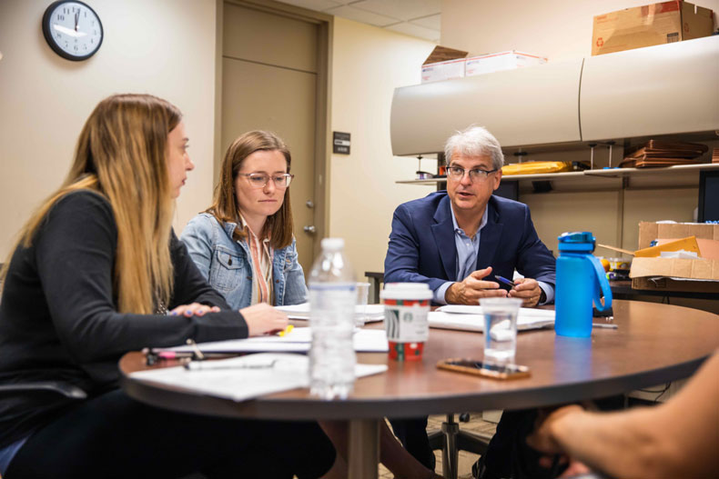 Innocence Clinic director Craig Trocino and law students, from left, Jacqueline Martinelli and Mackenzie Garrity, discuss an upcoming evidentiary hearing.
