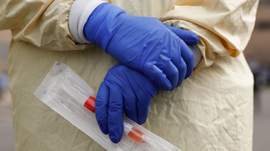 A nurse holds a swabs and test tube kit to test people for COVID-19, the disease that is caused by the new coronavirus. Photo: Associated Press
