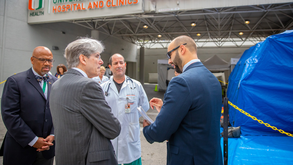 From left, Miller School of Medicine Dean Henri Ford; President Julio Frenk; Dr. David Lang, medical director of the emergency department at UHealth Tower; and Vincent Torres, emergency manager, confer at the medical campus on Tuesday. Photo: TJ Lievonen/University of Miami