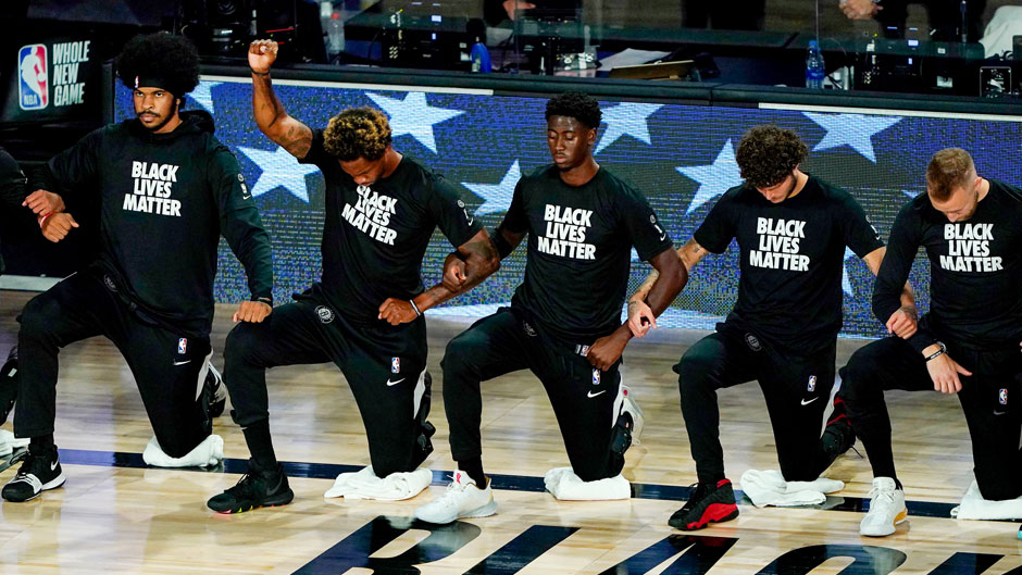 Brooklyn Nets' Lance Thomas, second from left, gestures as he and teammates kneel in honor of the Black Lives Matter movement prior to an NBA basketball game against the Portland Trail Blazers Thursday, Aug. 13, 2020 in Lake Buena Vista, Fla. (AP Photo/Ashley Landis, Pool)