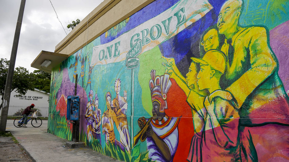 In this photo taken Saturday, July 6, 2013, a mural promoting the Bahamian heritage of the the Village West neighborhood of Coconut Grove in Miami, is shown on the outside wall of a grocery store. The community was settled by Bahamian immigrants in the 1880's, but has suffered from many years of decline and lack of investment. (AP Photo/Lynne Sladky)