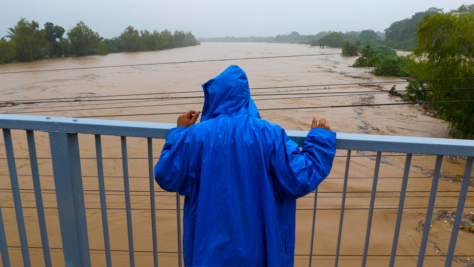 A man standing on a bridge looks out at the Ulua River in Progreso Yoro, Honduras, Wednesday, Nov. 4, 2020. Eta weakened from the Category 4 hurricane to a tropical storm after lashing the Caribbean coast for much of Tuesday, its floodwaters isolating already remote communities and setting off deadly landslides. (AP Photo/Delmer Martinez)