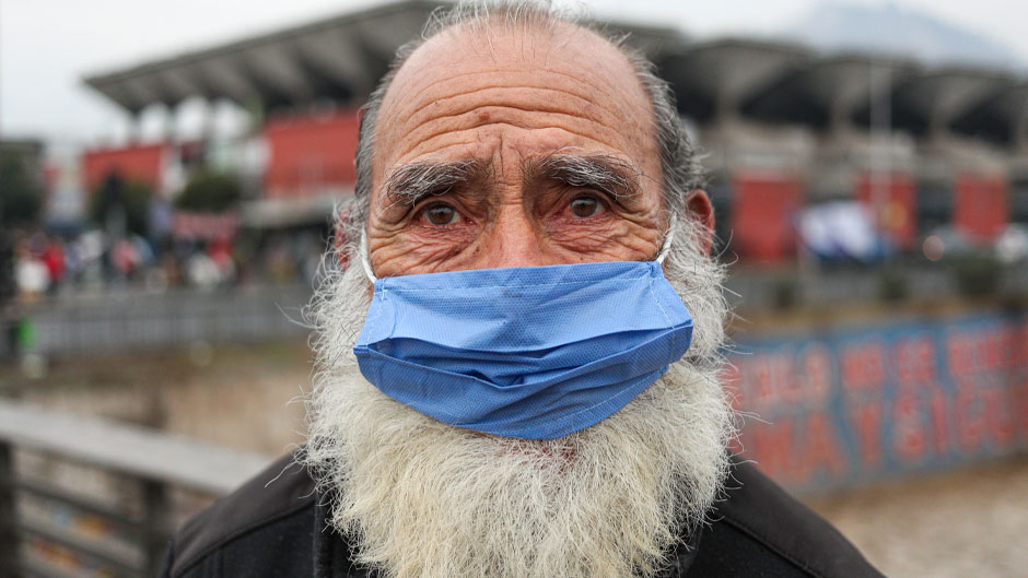 A man wearing a protective face mask as a precaution amid the new coronavirus pandemic, poses for a photo after buying groceries at a market in Santiago, Chile, Monday, June 8, 2020. With Latin America now the epicenter of the pandemic, but with hundreds of millions relying on these markets for food and livelihoods, the debate now centers on whether and how they can operate safely. (AP Photo/Esteban Felix)
