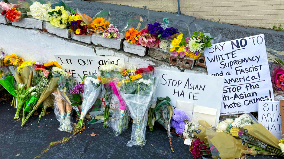Flowers, candles and signs are displayed at a makeshift memorial on Friday, March 19, 2021, in Atlanta. Robert Aaron Long, a white man, is accused of killing several people, most of whom were of Asian descent, at massage parlors in the Atlanta area. (AP Photo/Candice Choi)