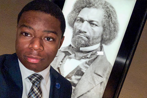 Douillon snapped a selfie with a portrait of Frederick Douglass.