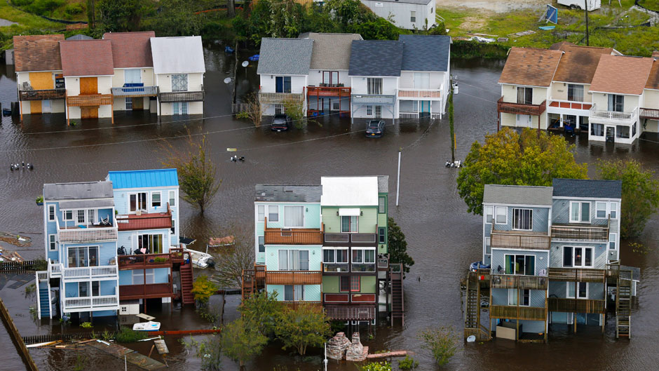 FILE - In a Sunday, Sept. 16, 2018 photo, homes along the New River are flooded as a result of high tides and rain from hurricane Florence which moved through the area in Jacksonville, N.C. As hurricane season starts Monday, May 31, 2020, most of North Carolina’s coastal counties are grappling with shortfalls or concerns about equipment and resources as they balance the dual threat of tropical weather and the COVID-19 pandemic. All 20 counties in the state’s coastal management zone told the Associated Press that COVID-19 is factoring into hurricane preparations. (AP Photo/Steve Helber, File)