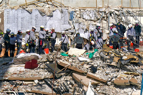 Rescue workers search in the rubble at the Champlain Towers South condominium, Monday, June 28, 2021, in the Surfside area of Miami. Many people are still unaccounted for after the building partially collapsed last Thursday. (AP Photo/Lynne Sladky)