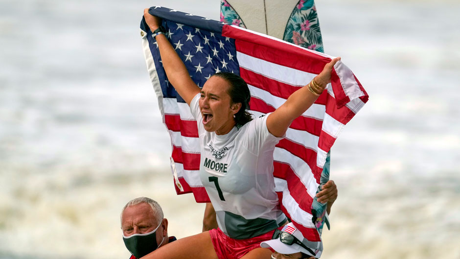 Carissa Moore, of the United States, celebrates winning the gold medal in the women's surfing competition at the 2020 Summer Olympics, Tuesday, July 27, 2021, at Tsurigasaki beach in Ichinomiya, Japan. (AP Photo/Francisco Seco)