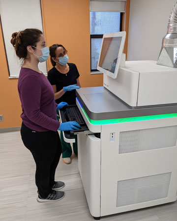 Research assistants Marissa Brooks and Yoslayma Cardentey review sequencing results produced by the NovoSeq instrument at the Sylvester Comprehensive Cancer Center Onco-Genomics Shared Resource.