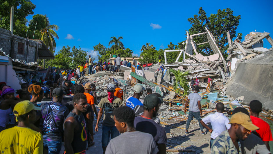 People search for survivors in a home destroyed by the earthquake in Les Cayes, Haiti, Saturday, Aug. 14, 2021. A 7.2 magnitude earthquake struck Haiti on Saturday, with the epicenter about 125 kilometers (78 miles) west of the capital of Port-au-Prince, the US Geological Survey said. (AP Photo/Joseph Odelyn)