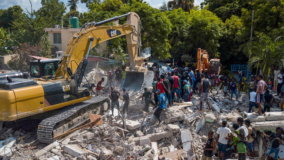 A bulldozer removes debris at the site of the collapsed Hotel Le Manguier in Les Cayes, Haiti, Monday, Aug. 16, 2021, two days after a 7.2-magnitude earthquake struck the southwestern part of the country. (AP Photo/Matias Delacroix)