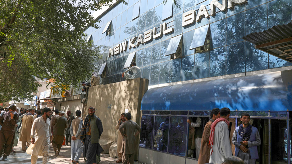 Afghans wait for hours to try to withdraw money, in front a bank, in Kabul, Afghanistan, Sunday, Aug. 15, 2021. Officials say Taliban fighters have entered Kabul and are seeking the unconditional surrender of the central government. (AP Photo/Rahmat Gul)