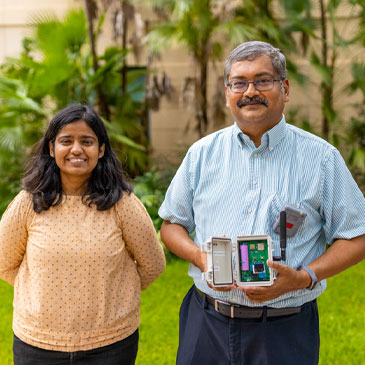 Doctoral student Shruti Choudhary, left, and Pratim Biswas, dean of the College of Engineering. Biswas holds a MAXIMA air quality sensor. Photo: TJ Lievonen/University of Miami
