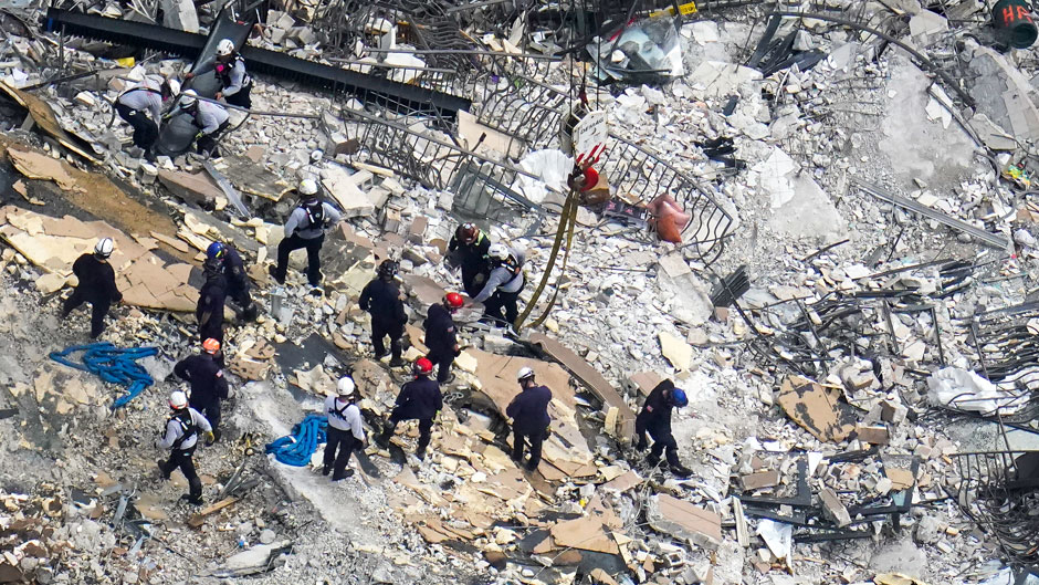 FILE - In this Saturday, June 26, 2021, file photo, rescue workers search in the rubble at the Champlain Towers South Condo, in Surfside, Fla. Even as the search continues over a week later for signs of life in the mangled debris of the fallen Champlain Towers South, the process of seeking answers about why it happened and who is to blame is already underway in Florida's legal system. (AP Photo/Gerald Herbert, File)