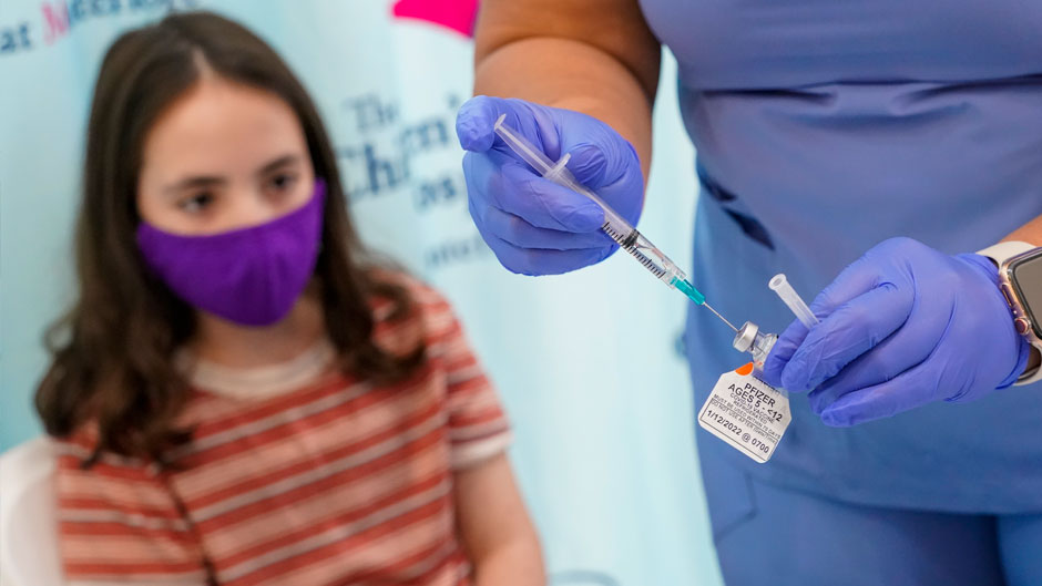 Jamie Onofrio Franceschini, 11, watches as RN Rosemary Lantigua prepares a syringe with her first dose of the Pfizer COVID-19 vaccine for children five to 12 years at The Children's Hospital at Montefiore, Nov. 3, 2021, in the Bronx borough of New York. (AP Photo/Mary Altaffer, File)