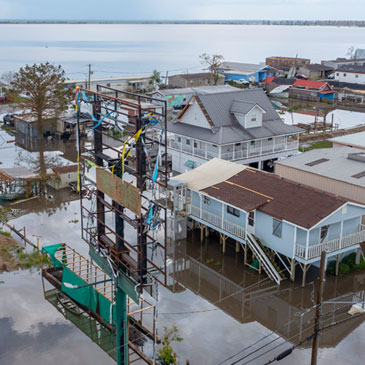 In this Tuesday, Aug. 31, 2021 file photo, flood waters surround storm damaged homes in Lafourche Parish, La., as residents try to recover from the effects of Hurricane Ida. The federal government rolled out a new program to calculate flood insurance rates that it says will be more precise and fair. (AP Photo/Steve Helber)
