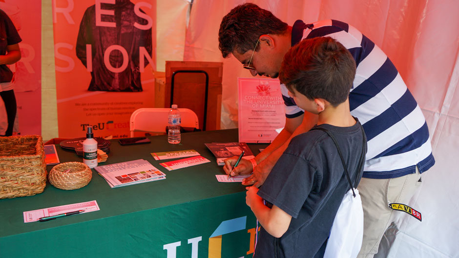 Patrons visit the University of Miami tent at the Miami Book Fair