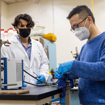 With Mert Akin looking on, mechanical engineering graduate assistant Zhiwei Yan connects the prototype of the lithium extraction unit to an electrochemical test station. Photo: Evan Garcia/University of Miami