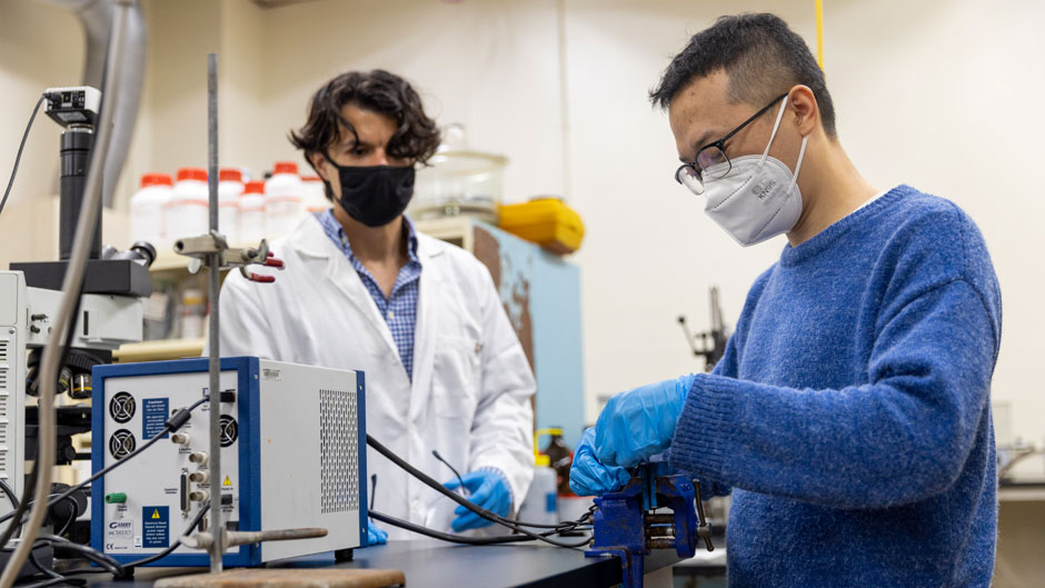 With Mert Akin looking on, mechanical engineering graduate assistant Zhiwei Yan connects the prototype of the lithium extraction unit to an electrochemical test station. Photo: Evan Garcia/University of Miami