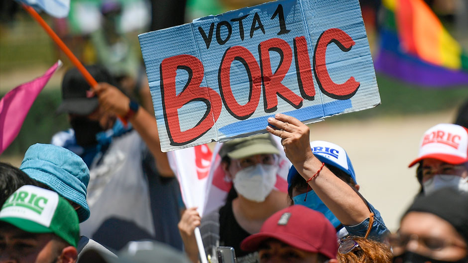 A supporter of Gabriel Boric, of the "I approve Dignity" coalition, holds up the Spanish message "Vote Boric" at the start of a campaign rally ahead of the presidential run-off election in Santiago, Chile, Thursday, Dec. 16, 2021. (AP Photo/Matias Delacroix)