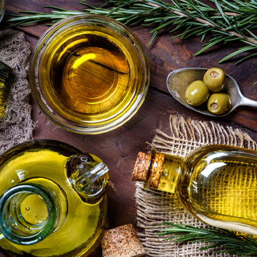 Top view of olives and olive oil bottles on table in a rustic kitchen 