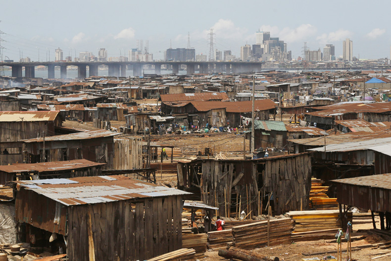 People in a slum work in a saw mill with downtown in the distance in Lagos, Nigeria, Tuesday May 12, 2020. Photo: The Associated Press