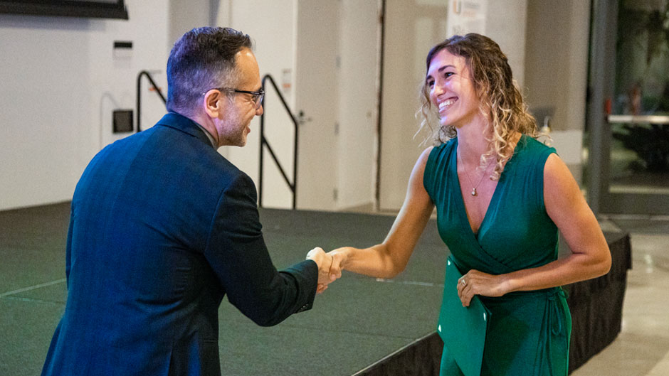 Guillermo Prado, dean of the Graduate School, congratulates first place winner Liv Williamson, a doctoral student in marine biology and ecology at the Rosenstiel School of Marine and Atmospheric Science. Photo: Diego Meza-Valdes/University of Miami