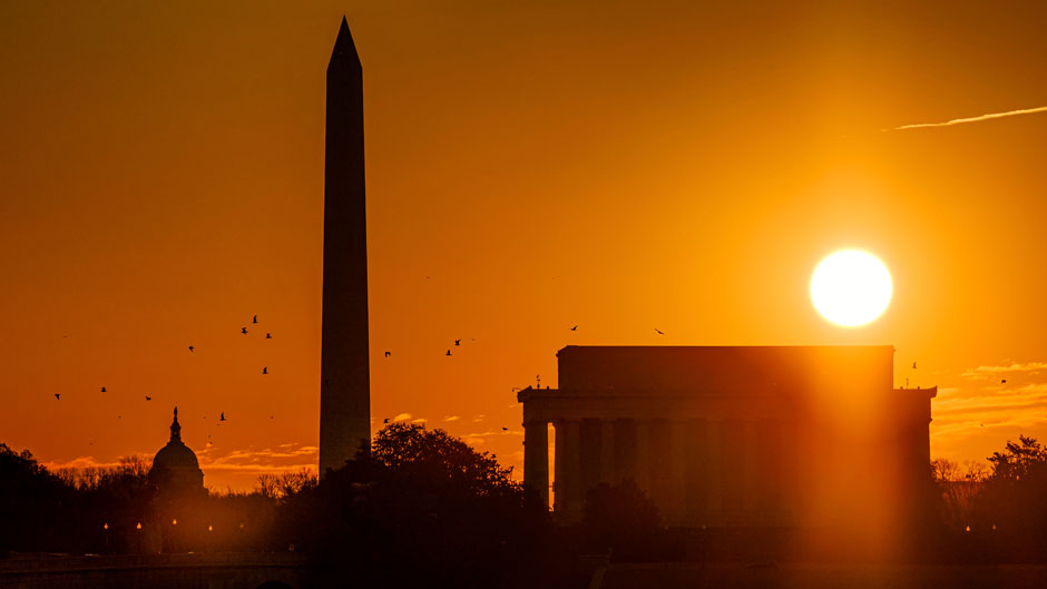 The sun rises above the Lincoln Memorial with the Washington Monument and the U.S. Capitol building in the background Saturday morning, March 13, 2021 in Washington. Sunrise will be an hour later in most places in the U.S. Sunday as Daylight Saving Time takes effect. (AP Photo/J. David Ake)