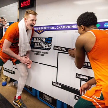 Members of the men's basketball team celebrate their advance in tournament play during March Madness.