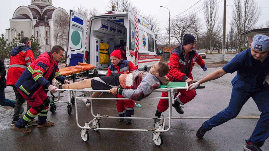 Ambulance paramedics move an injured man on a stretcher, wounded by shelling in a residential area, at a maternity hospital converted into a medical ward and used as a bomb shelter in Mariupol, Ukraine, Tuesday, March 1, 2022. (AP Photo/Evgeniy Maloletka)