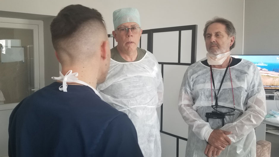 Miller School of Medicine surgeon Enrique Ginzburg, right, and John Holcomb, center, a surgeon from the University of Alabama Birmingham, consult with Hnat Herych, chief of surgery at a Ukrainian hospital. 