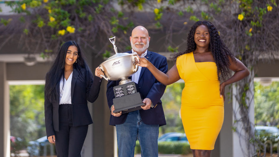 Iman Sami, David Steinberg, and Delphine Djomo pose with the ACC Championship trophy. Photo: Evan Garcia/University of Miami