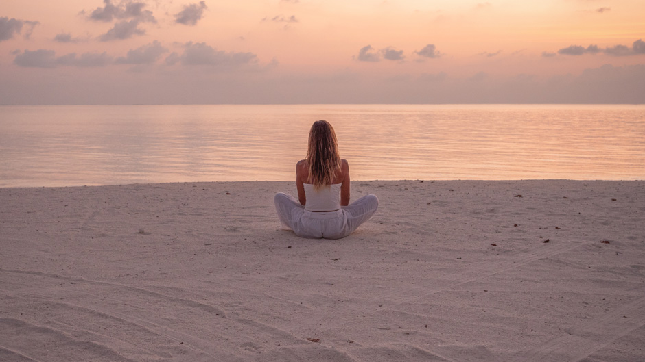 Woman exercising yoga at sunrise enjoying sea view the beach/mystockimages