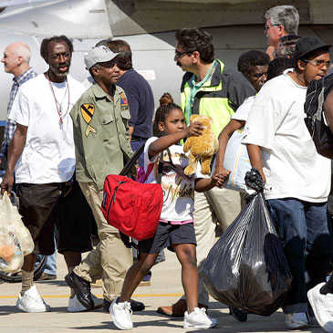 Evacuees of Hurricane Katrina arrived at Camp Edward on Cape Cod, Mass., Thursday, Sept. 8, 2005. A plane carrying more than 100 Hurricane Katrina refugees landed at the military base in Mass. (AP Photo/Chitose Suzuki)