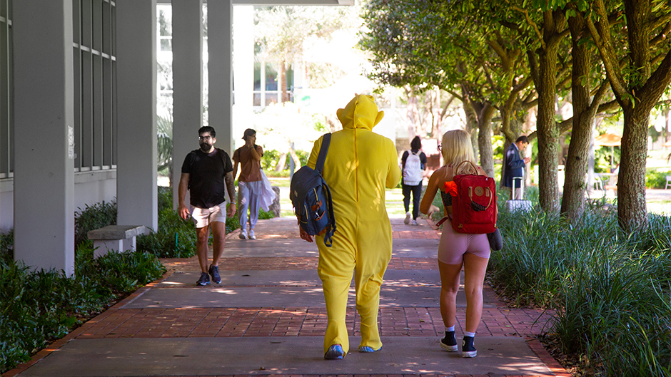 Hunter Bass, in the yellow tellietubbies outfit,  a sophmore, in the school of Art and Science,  strolls by the Library on the way to class with a friend. Bass was one of a few students who got into the Halloween spirit Monday on campus.