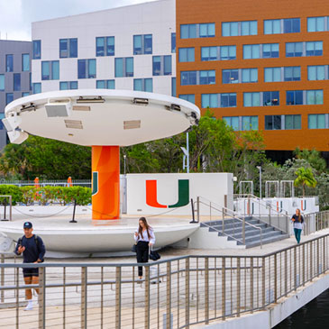 Students walk across the Fate Bridge on the Coral Gables Campus.