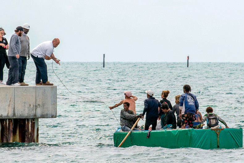 Residents help Cuban migrants to shore on Stock Island, near Key West, Fla., Friday, Aug. 12, 2022. The number of Cubans leaving the island will reach an all-time high this year. The U.S. Coast Guard has intercepted many at sea, but many more are crossing the U.S.-Mexican border. (AP Photo/Mary Martin)