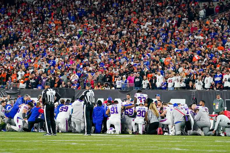 Buffalo Bills players kneel after teammate Damar Hamlin is injured during the first half of an NFL football game against the Cincinnati Bengals, Monday, Jan. 2, 2023, in Cincinnati. (AP Photo/Jeff Dean)