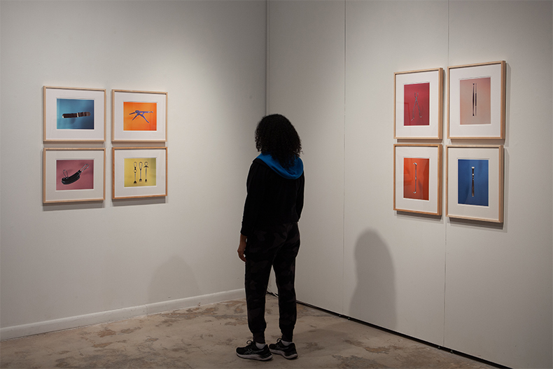Guest views prints from "The Precipice," an exhibition of photographs from the first monograph by the Miami-based photographer Tony Chirinos, currently on display at the University of Miami gallery located inside the Wynwood Building.  