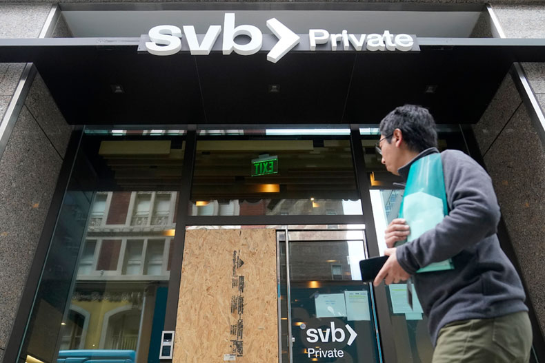 A pedestrian passes a Silicon Valley Bank branch in San Francisco, Monday, March 13, 2023. As the primary regulator of the bank, the Federal Reserve is coming under sharp criticism from financial watchdogs and banking experts. (AP Photo/Jeff Chiu)