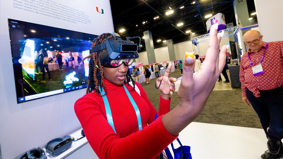 Miami Edison Senior High School student Aricely Villafuerte checks out a virtual reality display to a medical training device at the University of Miami's booth. Photo: Joshua Prezant/University of Miami