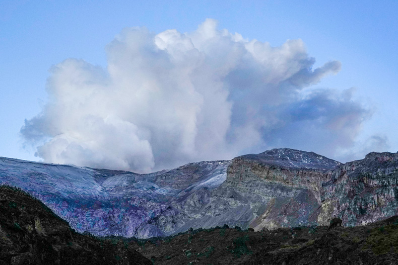 The Nevado del Ruiz volcano spews fumes near Villahermosa, Colombia, Tuesday, April 11, 2023. Colombian officials evacuated some families after the volcano showed high levels of seismic activity. (AP Photo/Fernando Vergara)